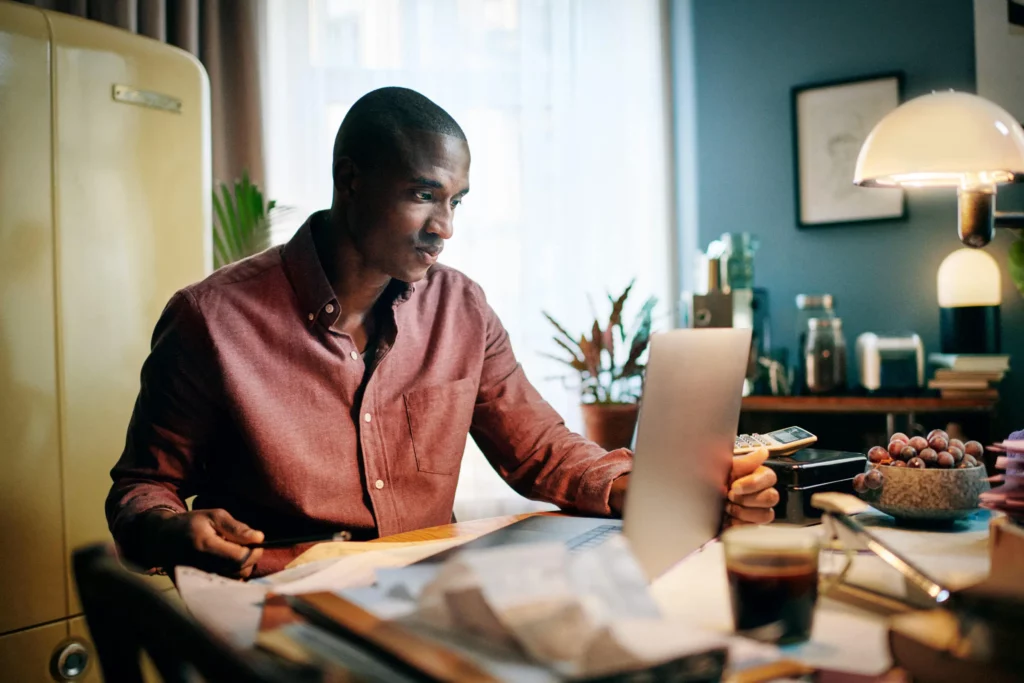 Mann som bruker en bærbar datamaskin i hjemmemiljø